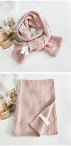 Detail of pink knitted scarf with 3D heart pattern and woven material texture