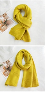 Detailed knit texture of bright yellow winter scarf with raised heart pattern