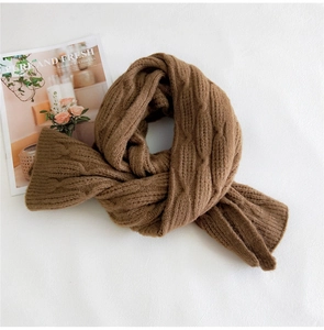 Detailed texture of brown cable knit scarf with classic patterns for winter warmth
