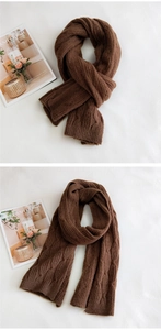 Close-up of dark brown cable knit scarf showing thick warm wool texture and patterns