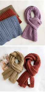 Detail of soft cable knit texture on thick scarves in multiple winter colors