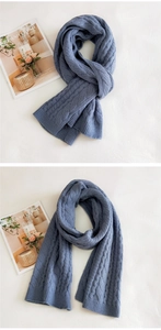 Close-up of chunky cable knit texture on a soft dusty blue winter scarf detail