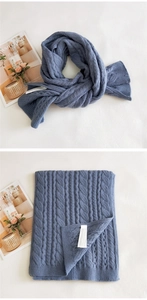 Detail of cable knit pattern and ribbed edges on a thick Morandi blue winter scarf