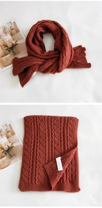 Detailed view of brick red cable knit scarf with thick wool texture and ribbed edges