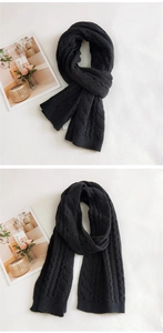 Detailed close-up of a thick black cable knit scarf with soft texture and ribbed edges