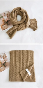 Close-up of thick khaki cable knit scarf texture and label on a clean background