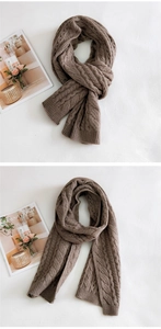 Detailed close-up of brown chunky cable knit scarf with ribbed hem and thick wool texture
