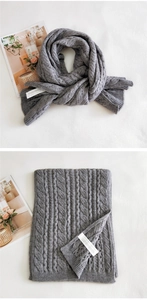 Detail of grey cable knit scarf showing thick texture and authentic washing label