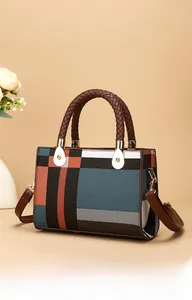 Detail of checkered handbag with navy and orange pattern featuring braided handles