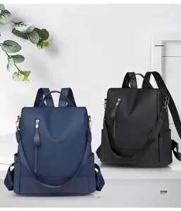 Detailed view of navy blue and black PU leather anti-theft backpacks for women with zip pockets