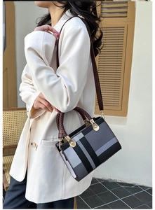 Classic checkered handbag with woven handles and detachable strap shown on a model