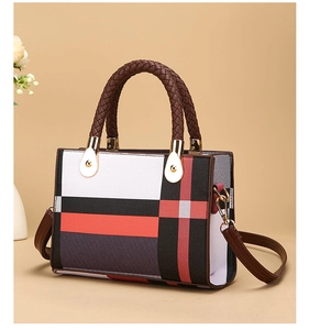 Close-up of woven brown leather handles and classic plaid pattern on the shoulder bag