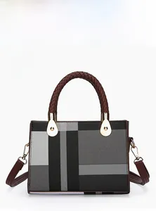 Detail view of large check pattern handbag with brown woven handles and gold hardware