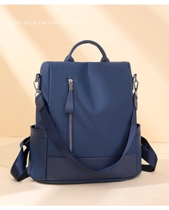Detail view of deep blue PU leather backpack featuring vertical silver zippers and side pockets