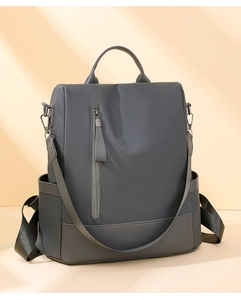 Detail view of dark grey PU leather backpack with lychee texture and metallic zippers