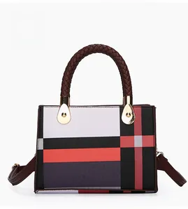 Detail of red and black geometric color block handbag with brown woven leather handle
