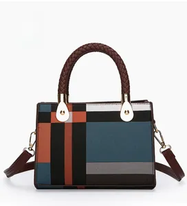 Detail of color block handbag with woven handle and gold-tone metal hardware