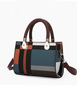 Detail view of the textured plaid fabric and woven round handle on the fashion handbag