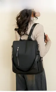 Model wearing a large capacity black PU leather backpack for travel and daily school use