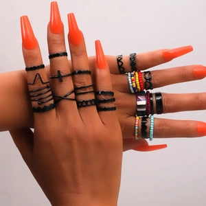 Mixed style ring set featuring metal bands and colorful beads worn by a model