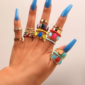 Colorful resin ring set featuring heart charms and beads shown on model hand