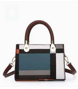 Rear view of geometric color-block handbag with woven handles and detachable strap