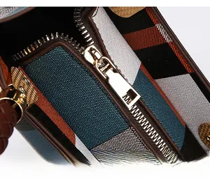 Close-up of premium light gold metal zipper on a stylish plaid textured handbag