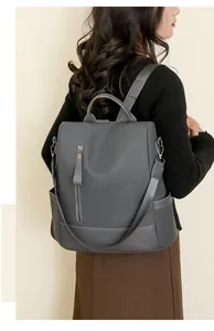 Detail view of dark grey PU leather backpack showing high-capacity design on model