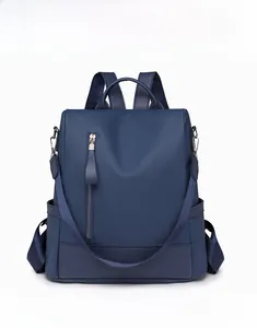 Detail of navy blue PU leather backpack showing lychee texture and silver zipper pocket