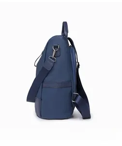 Side view of dark blue pebbled leather backpack showing side zipper pocket and silver hardware