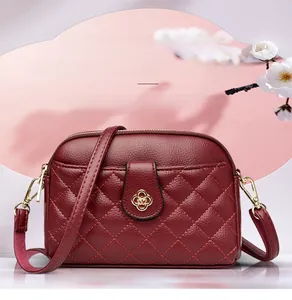 Detailed view of red quilted leather crossbody bag with golden flower metal clasp
