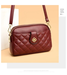 Detail of burgundy quilted leather square bag with gold floral clasp and litchi texture