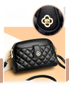 Detail of black quilted shoulder bag featuring gold floral clasp and premium leather texture