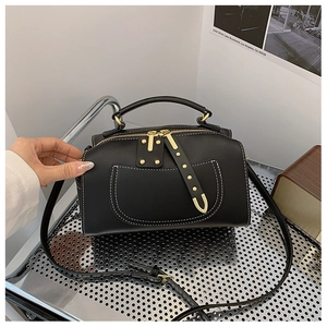 Sac bandoulière noir en cuir minimaliste avec coutures blanches contrastées
