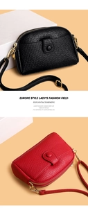 Close-up of litchi grain leather texture and gold hardware on red and black crossbody bags