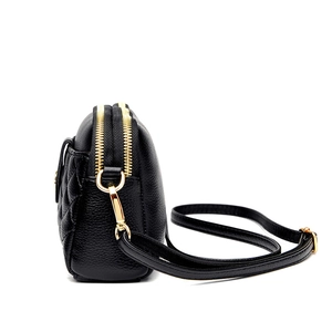 Black pebbled leather crossbody bag with quilted diamond pattern and double gold zippers
