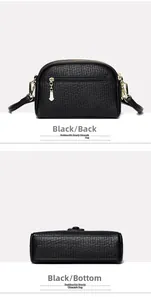 Detail view of black textured shoulder bag showing back zipper pocket and bottom base