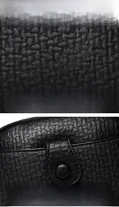 Macro detail of black litchi grain leather texture and precision stitching on the bag