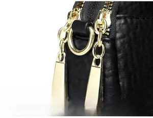 Close-up of premium black lychee leather bag featuring double golden metal zippers