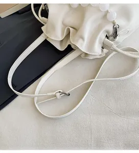 Detail of adjustable strap and pearl handle on white ruched cloud bag for women