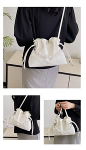 Detail view of a white ruched cloud bag with pearl handle shown in various styling ways