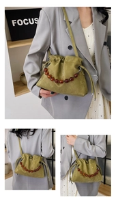 Detail of olive green pleated cloud bag with amber beads and drawstring closure