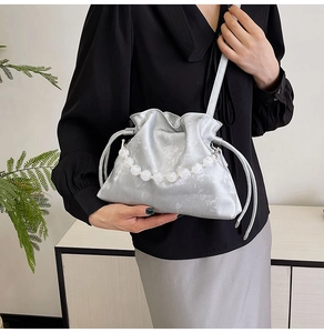 Detail of silver pleated cloud bag with elegant large pearl handle chain for women