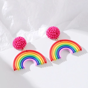 Detail of colorful rainbow seed bead earrings with pink spheres on a white tiered background