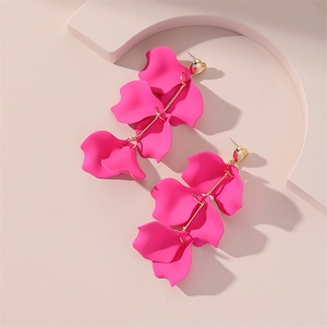 Détail des boucles d'oreilles pétales rose vif à plusieurs couches avec cœur doré