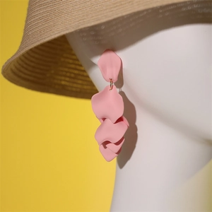 Gros plan de boucles d'oreilles pétales roses sur un modèle avec un style de plage