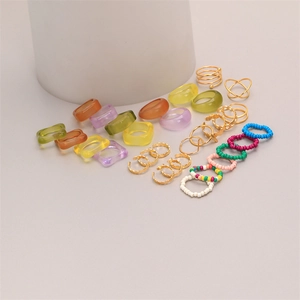 Vue détaillée de bagues en résine colorée, bagues ouvertes en métal et bijoux en perles
