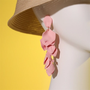 Détail des boucles d'oreilles à pales roses superposées sur mannequin blanc