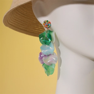 Détail de boucles d'oreilles pendantes faites main avec pétales irisés et perles