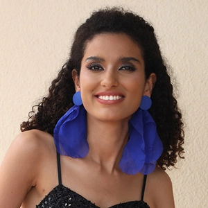 Close-up of blue handmade flower tassel earrings with lightweight translucent fabric petals